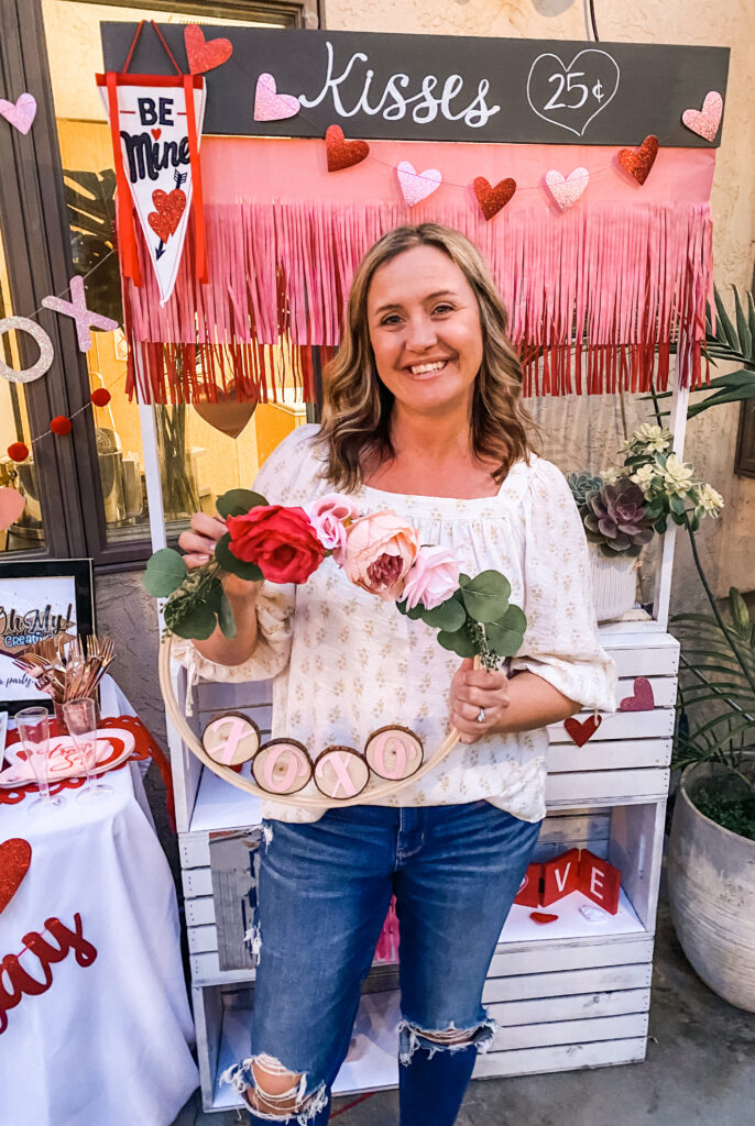 diy valentine's day wreath with faux flowers and wood slices spelling "xoxo"