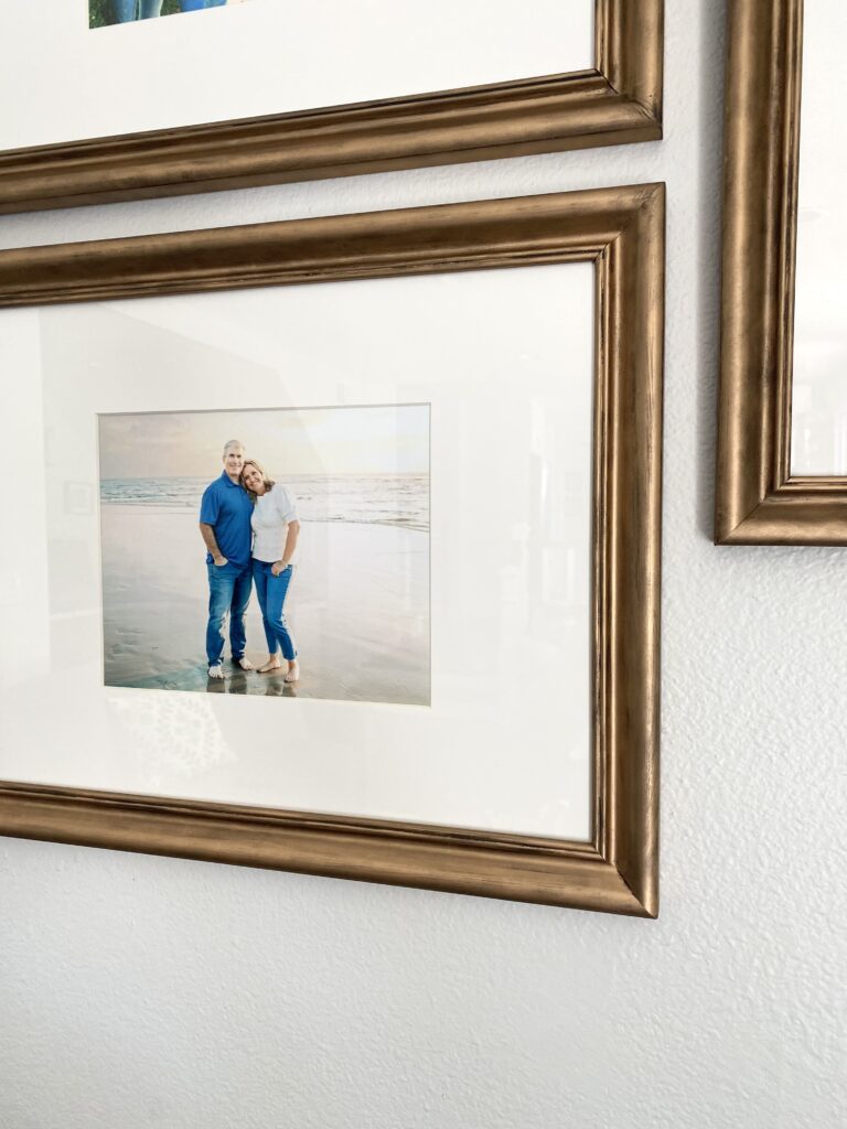 A photo of a couple on the beach in a gold picture frame with an aged patina.