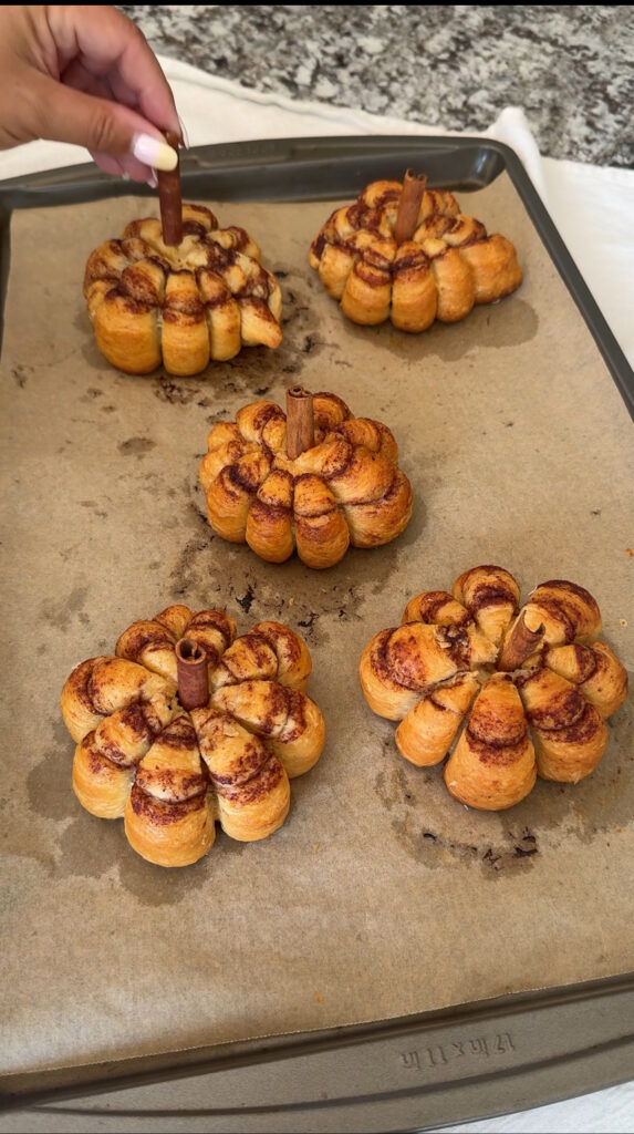 Cooked cinnamon rolls with a cinnamon stick stem