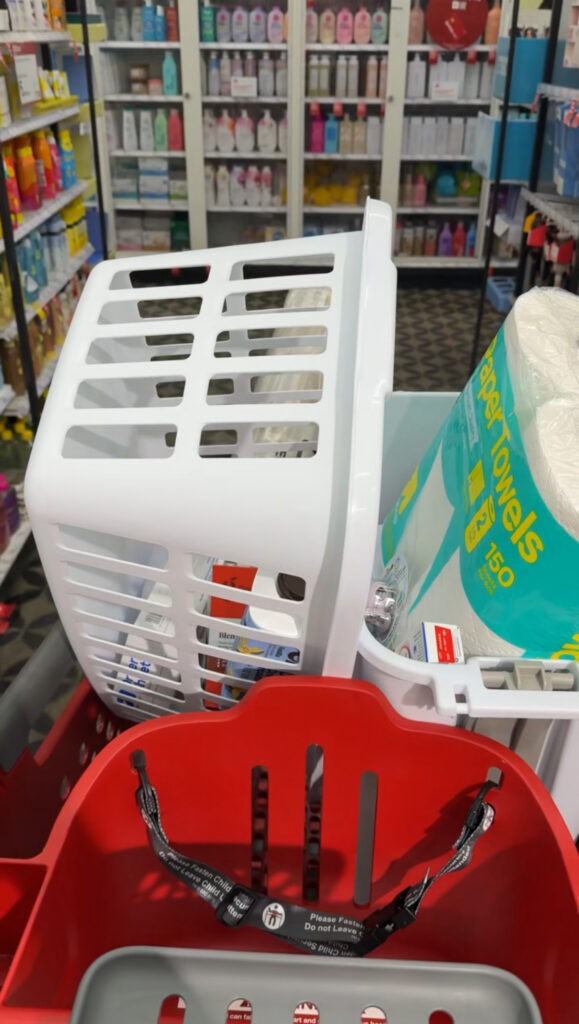 a Target shopping cart holding a laundry basket, paper towels, and other items