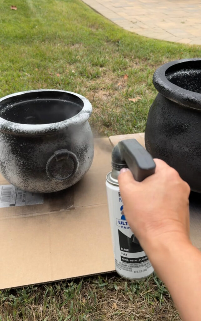 plastic cauldron getting a coat of black spray paint
