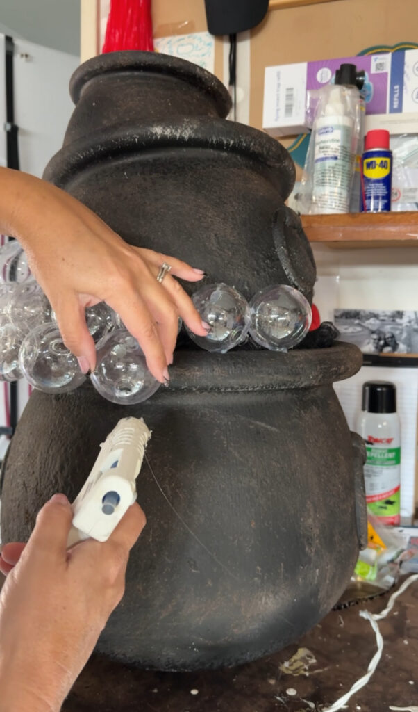 use hot glue to stick clear plastic balls to the cauldron to look like bubbles